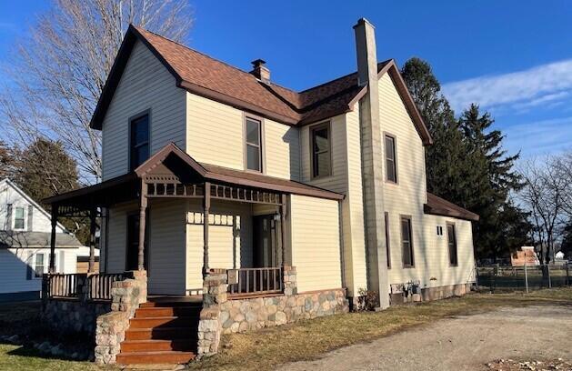 view of front of property featuring covered porch and a chimney