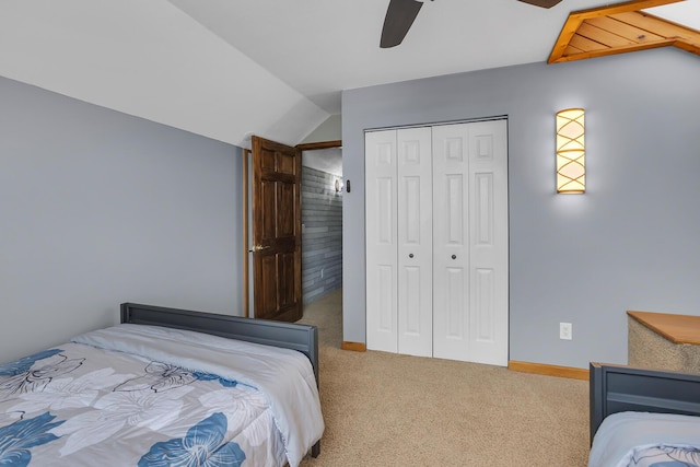 carpeted bedroom featuring a closet, ceiling fan, baseboards, and vaulted ceiling
