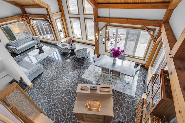 living room featuring beamed ceiling, a chandelier, and a wealth of natural light