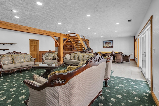carpeted living area featuring a textured ceiling, visible vents, stairs, tile patterned floors, and recessed lighting