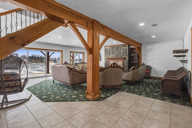 tiled living area featuring visible vents, a fireplace, recessed lighting, and a textured ceiling