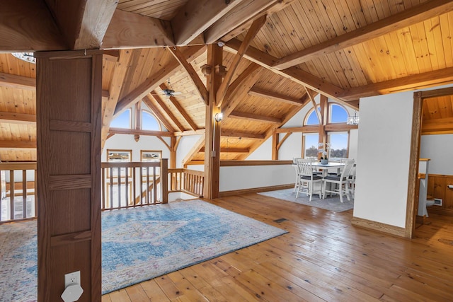 interior space with baseboards, a ceiling fan, vaulted ceiling with beams, wooden ceiling, and wood-type flooring