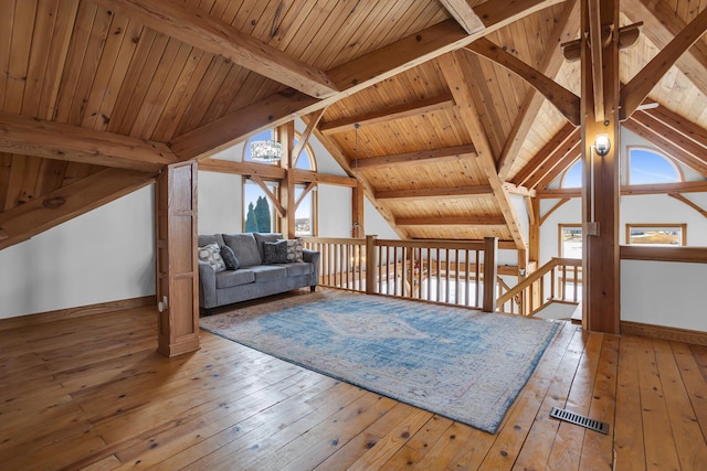 additional living space featuring hardwood / wood-style floors, vaulted ceiling with beams, baseboards, and visible vents