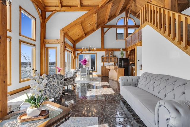 living area with baseboards, a chandelier, marble finish floor, wood ceiling, and beam ceiling