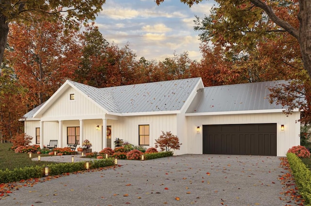 modern farmhouse style home featuring a garage, driveway, and metal roof