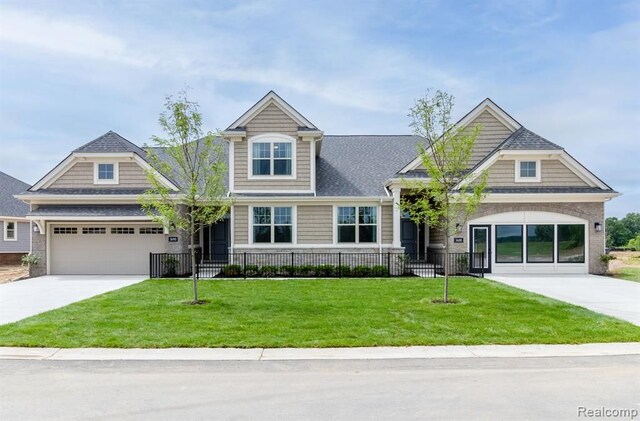 view of front of property featuring concrete driveway, a garage, and a front lawn