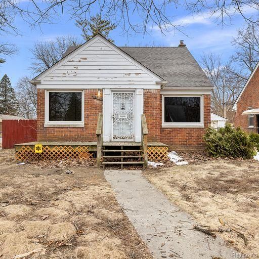 bungalow featuring brick siding, roof with shingles, and entry steps