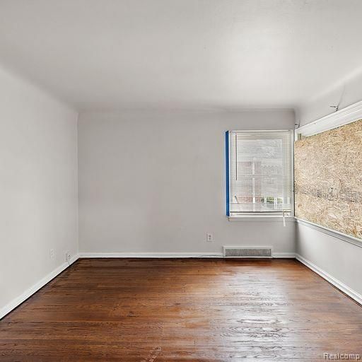 spare room featuring visible vents and wood finished floors