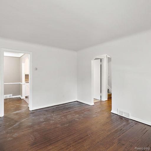 spare room featuring visible vents and wood finished floors