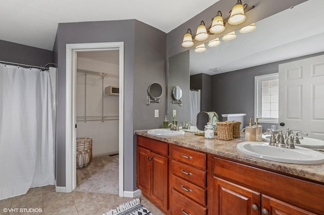 bathroom featuring double vanity, a shower with curtain, a sink, and tile patterned floors