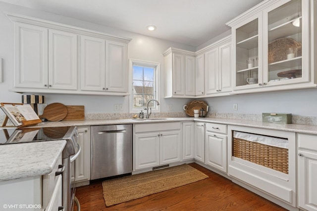 kitchen with light countertops, appliances with stainless steel finishes, glass insert cabinets, white cabinets, and a sink