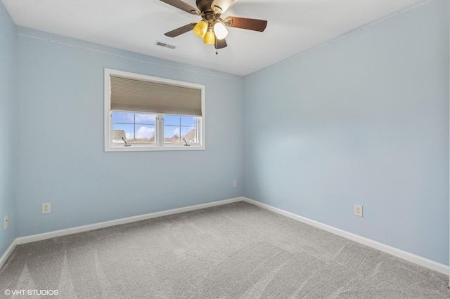 carpeted empty room with ceiling fan, visible vents, and baseboards