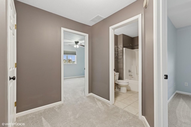 hall featuring baseboards, visible vents, carpet flooring, and tile patterned floors