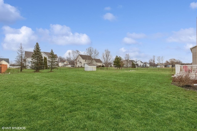 view of yard featuring an outbuilding, a shed, and fence