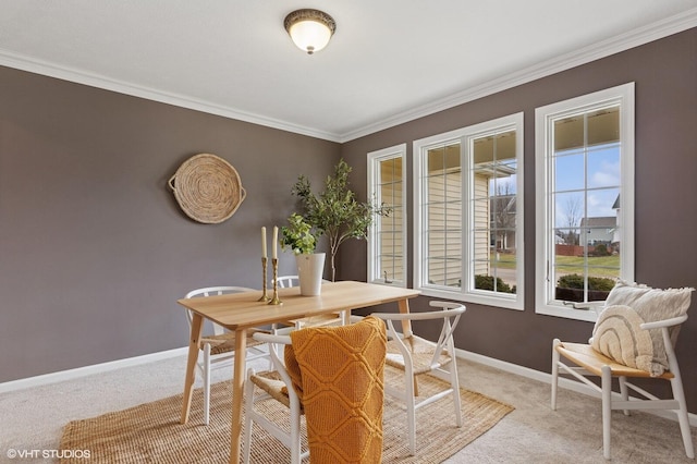 dining room with light colored carpet, crown molding, and baseboards