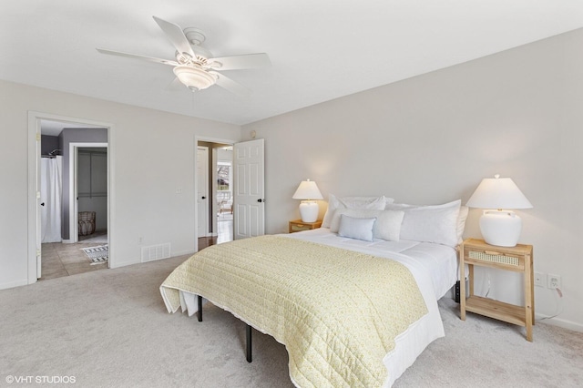 bedroom featuring visible vents, a spacious closet, light carpet, ceiling fan, and baseboards