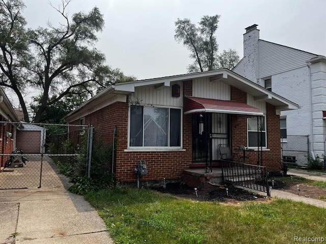 bungalow-style house featuring a gate, a porch, and brick siding