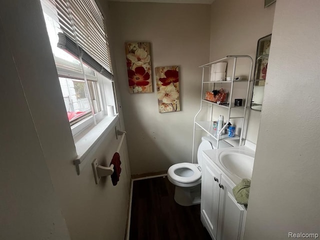 half bathroom featuring vanity, toilet, and wood finished floors