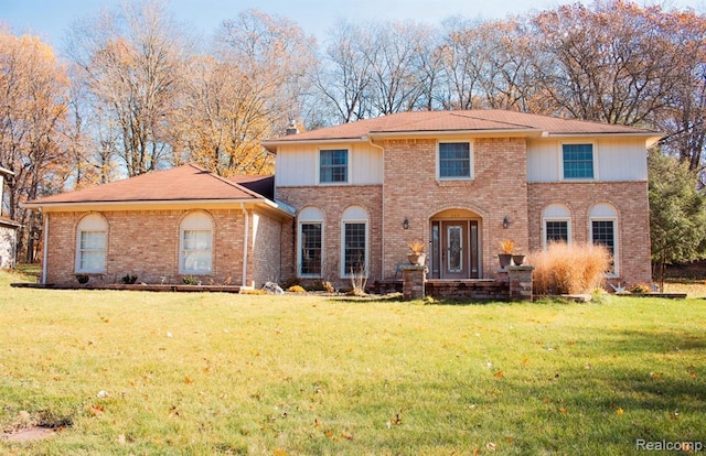 view of front of house with brick siding and a front lawn