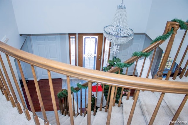 stairs with a notable chandelier