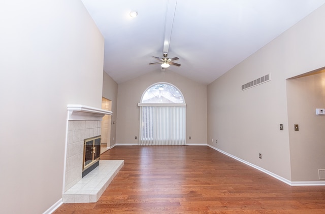 unfurnished living room featuring a fireplace, visible vents, vaulted ceiling, wood finished floors, and baseboards