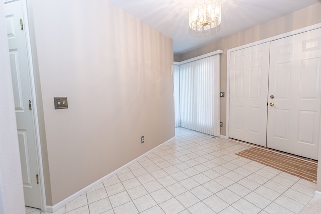 entryway with baseboards, light tile patterned flooring, and an inviting chandelier