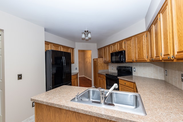 kitchen featuring a sink, light countertops, black appliances, tasteful backsplash, and brown cabinetry