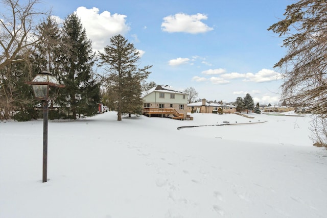 yard covered in snow featuring a wooden deck