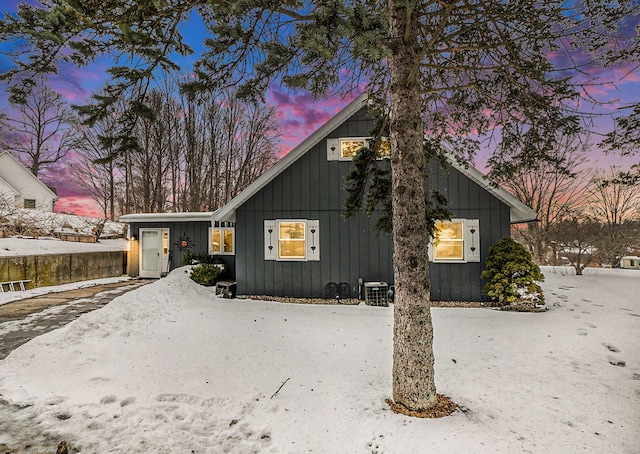 view of front facade featuring central AC unit and board and batten siding