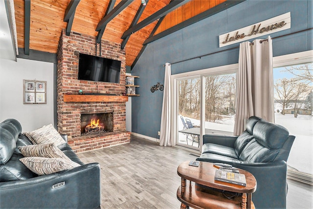 living room featuring beam ceiling, a fireplace, wood finished floors, and wood ceiling