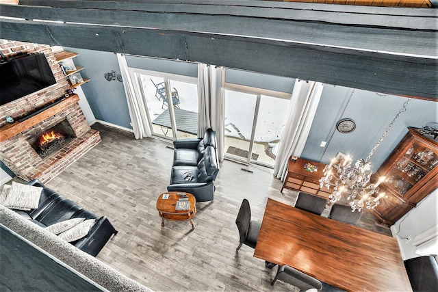 living room with a brick fireplace, wood finished floors, and visible vents