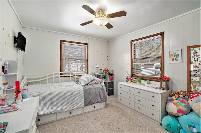 carpeted bedroom with ornamental molding and a ceiling fan