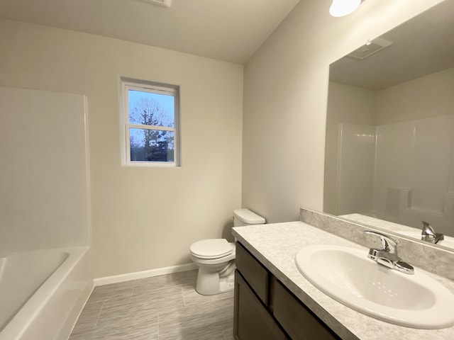 bathroom featuring baseboards, vanity, and toilet