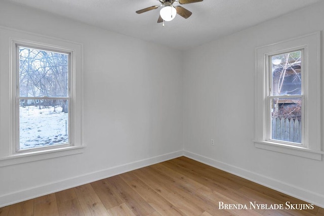 unfurnished room with ceiling fan, light wood-style floors, and baseboards