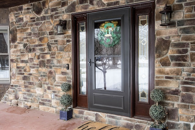 entrance to property with stone siding and brick siding