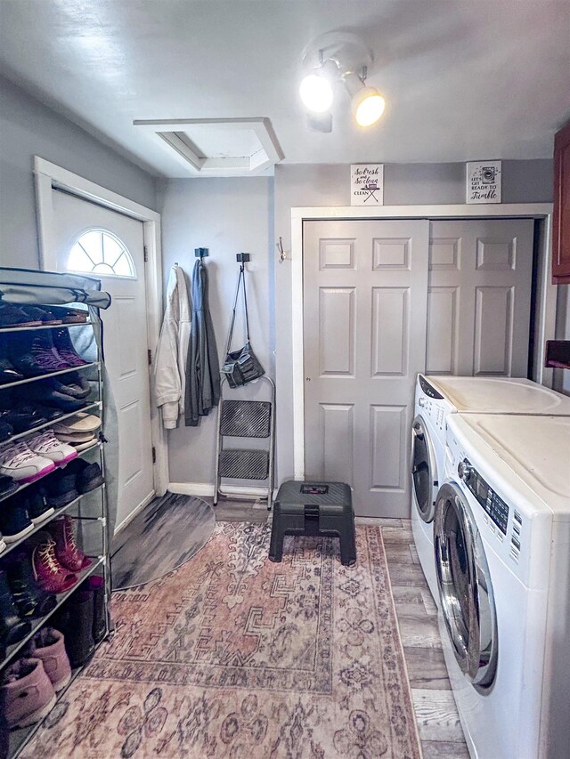 laundry room featuring light wood-type flooring, laundry area, attic access, and washer and clothes dryer