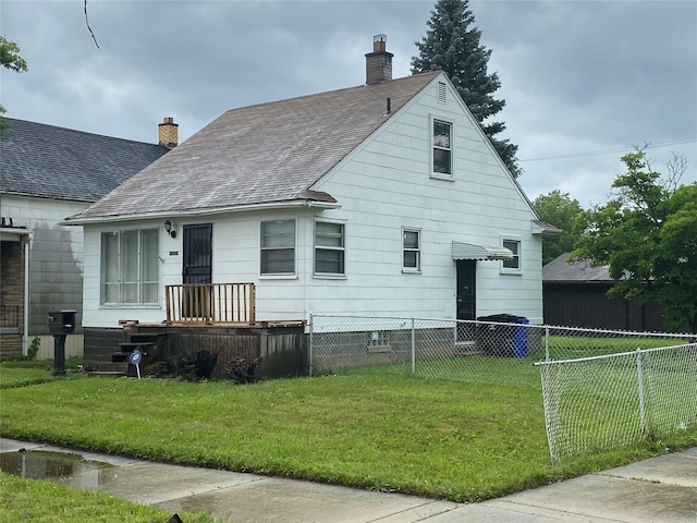 exterior space featuring a yard, a shingled roof, a chimney, and fence