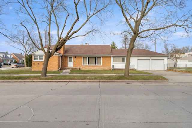 view of front of house with brick siding, driveway, a chimney, and a front lawn