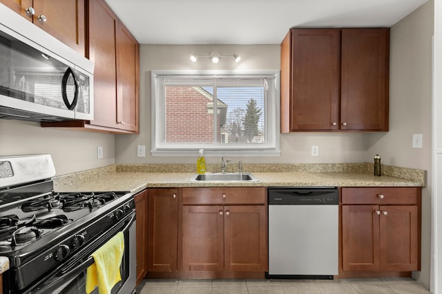 kitchen featuring light tile patterned floors, appliances with stainless steel finishes, light countertops, and a sink