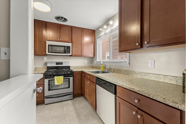 kitchen featuring stainless steel appliances, light countertops, a sink, and visible vents