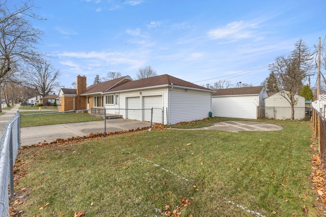 view of side of home featuring a yard, a fenced backyard, driveway, and a garage