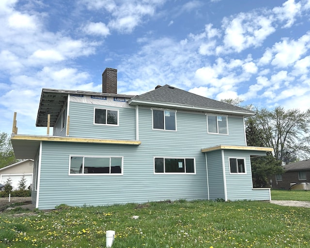 back of house featuring a yard and a chimney