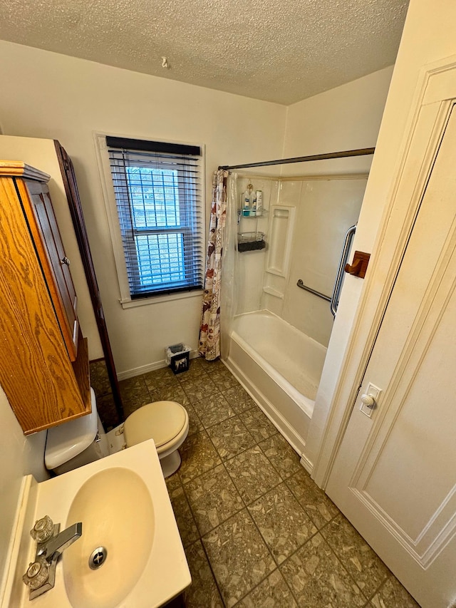 bathroom with a textured ceiling, toilet, a sink, baseboards, and shower / bath combo