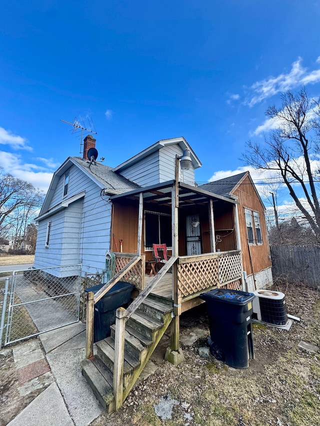 view of front of property with a shingled roof and central air condition unit