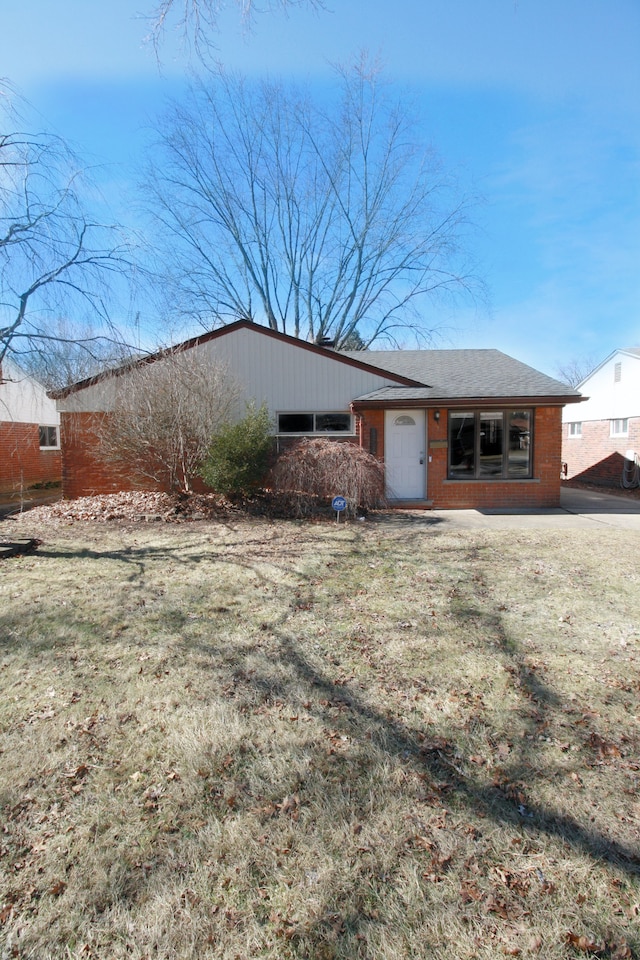 view of front facade with brick siding and a front yard