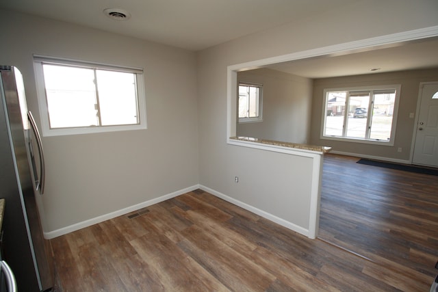 empty room featuring baseboards, visible vents, and dark wood-type flooring