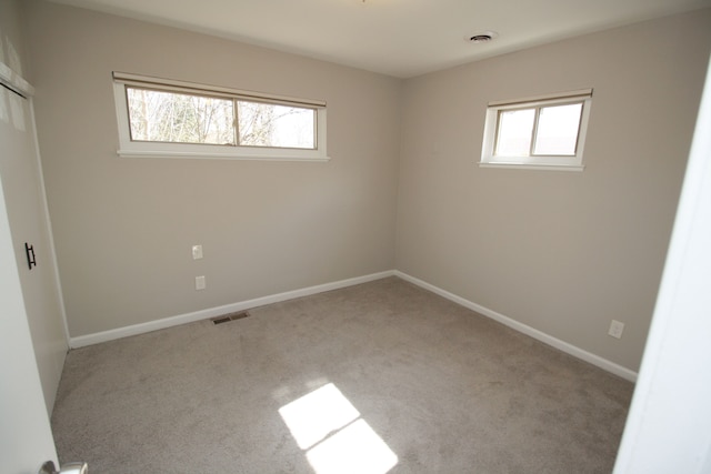 carpeted empty room with visible vents and baseboards