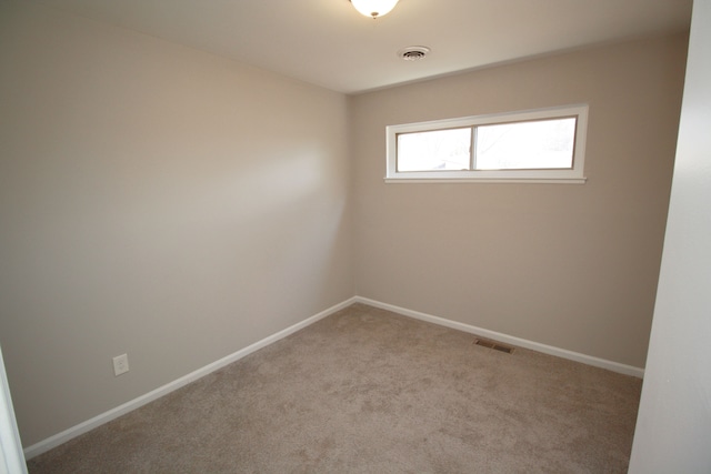 carpeted empty room featuring visible vents and baseboards