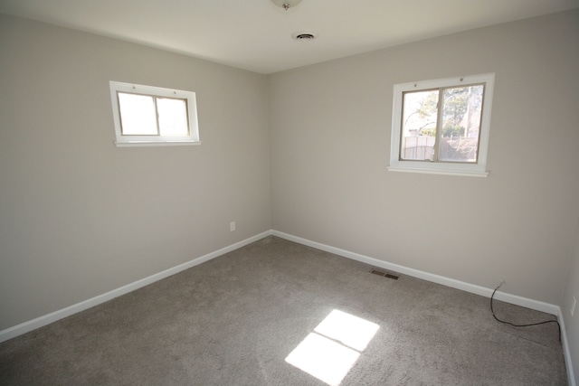 carpeted empty room featuring visible vents and baseboards