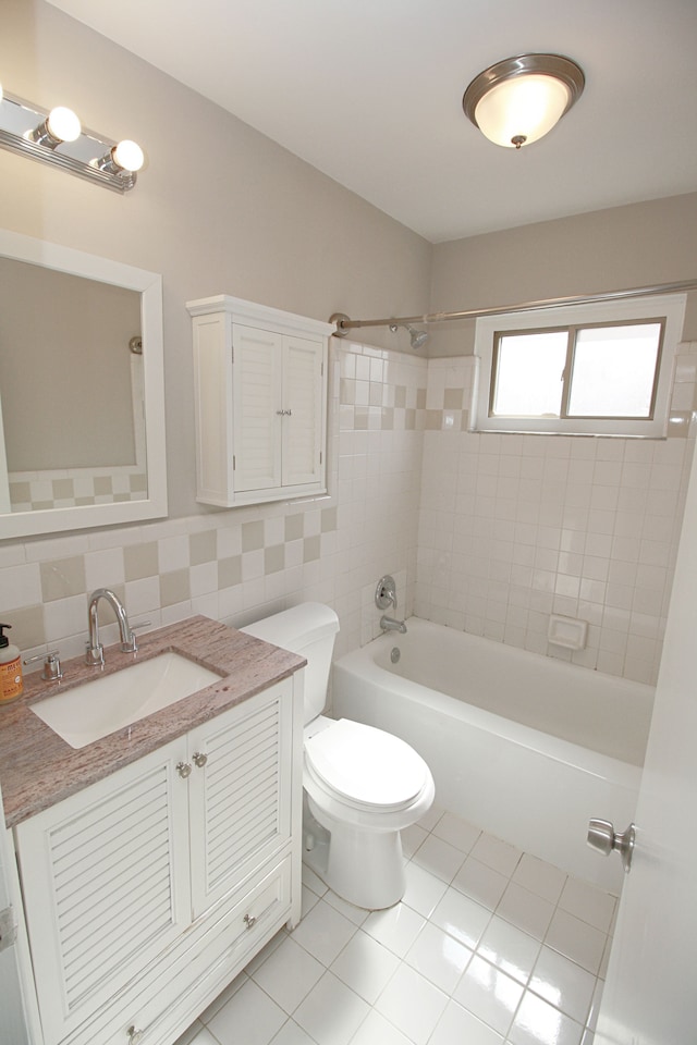 bathroom with toilet, tile patterned flooring, vanity, tile walls, and shower / bathing tub combination